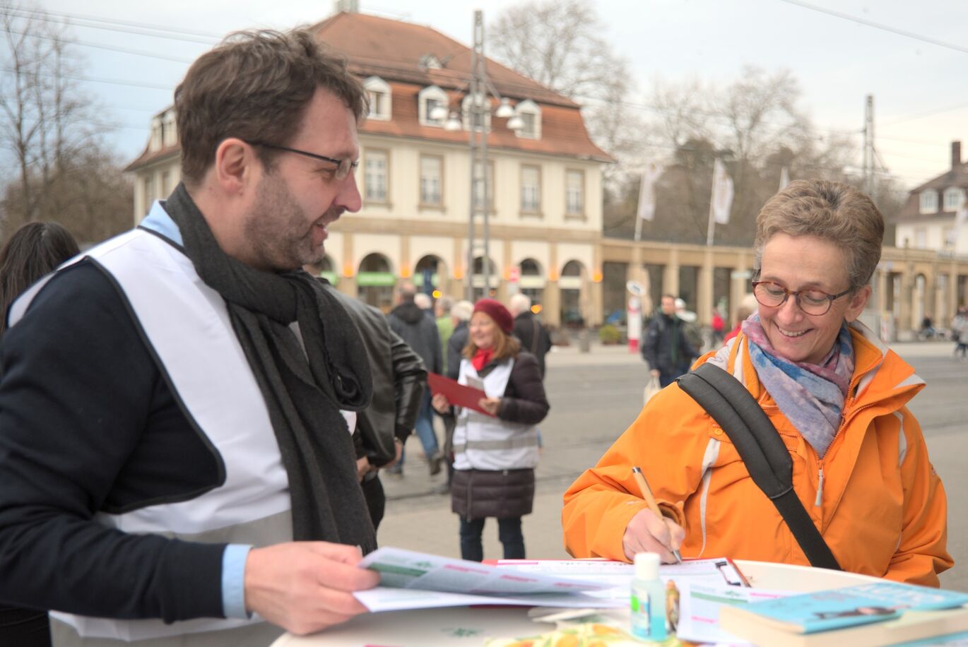 Eine Bürgerin unterschreibt an einem Sammelstand für den Fuß- und Radentscheid Karlsruhe