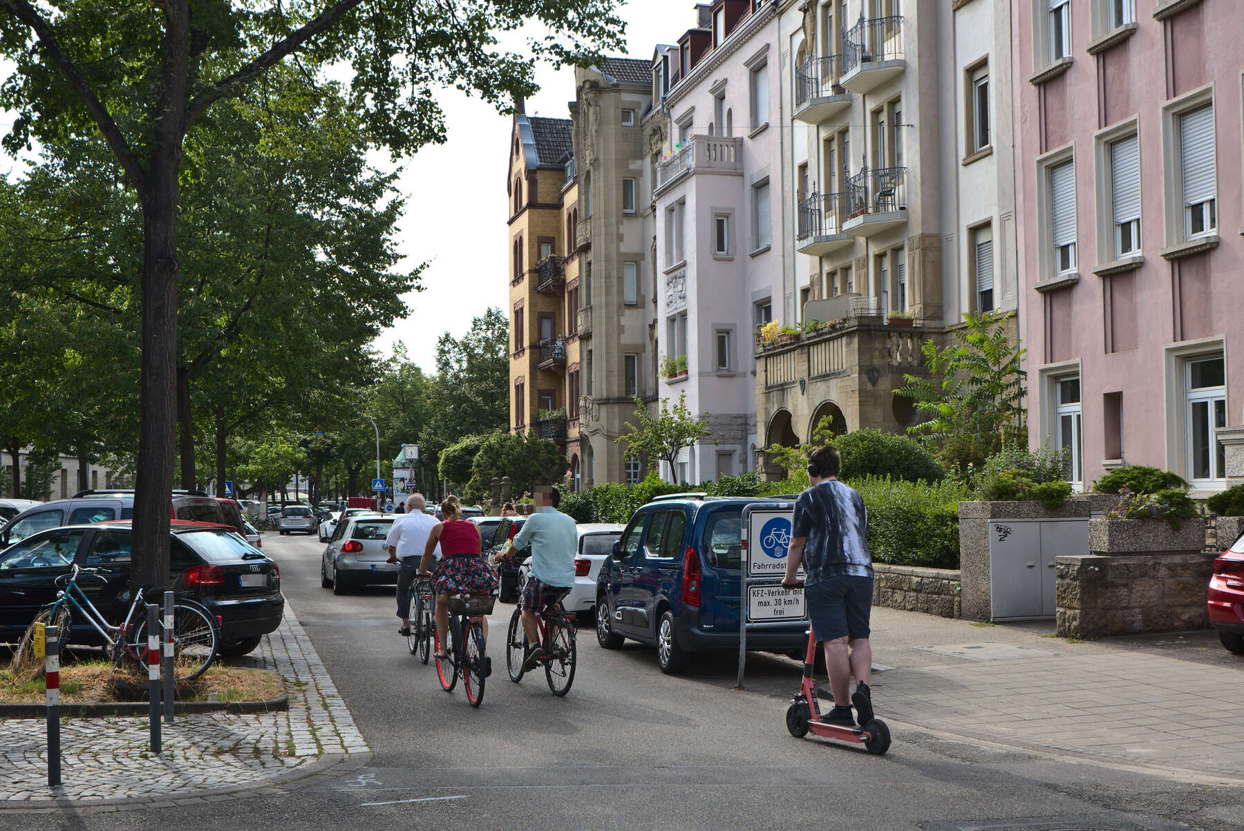 Foto der Sophienstraße an der Kreuzung Körnerstraße, mehrere Radfahrende fahren hinter einem PKW Richtung Westen